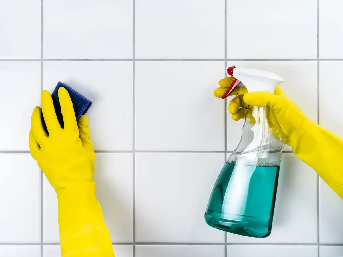 Cleaning tiles and grout with gloves and spray bottle