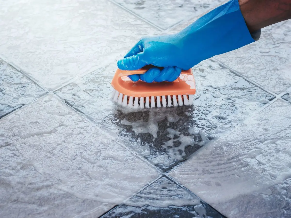 Scrubbing tiles with a brush